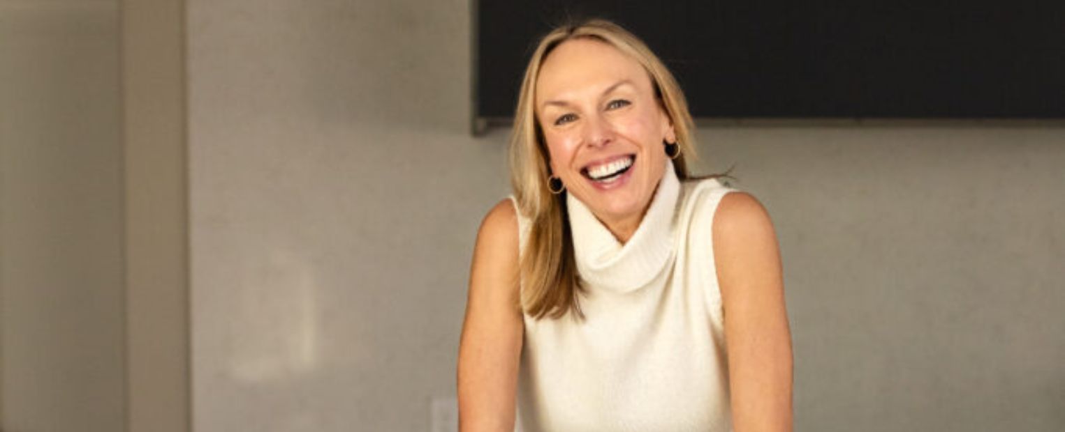 Psychologist Sarah Hill sits on a kitchen counter.